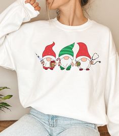 "How adorable is this Festive Nurse Sweatshirt? This is perfect for your co-worker, or yourself! This \"ugly\" Christmas sweatshirt comes in other colors and quotes so be sure to check out the storefront if this isn't exactly what you're looking for! This unisex heavy blend crewneck is made of polyester and cotton to provide a comfortable and cozy feel. The collar is ribbed knit and retains its shape after every wash.  ITEM DETAILS:  -50% cotton, 50% polyester -Medium-heavy fabric  -Loose fit -Sewn-in label -Runs true to size, BUT if you're looking for a more \"baggy\" fit we suggest sizing up! **Please note These colors ALL come with the same color lettering and shades may appear slightly different based on which color sweatshirt you choose *Mock-up proportions may vary from the actual pr Elf Legs, Color Sweatshirt, Nurse Christmas, Physician Assistant, Gnome Christmas, Nurse Sweatshirt, Christmas Style, Christmas Fashion, Christmas Sweatshirts