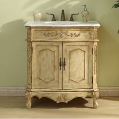 a bathroom sink sitting under a mirror on top of a wooden cabinet next to a green wall