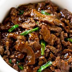 a white bowl filled with meat and vegetables