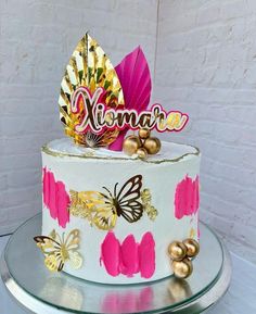 a white cake with pink and gold decorations