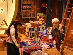 two dolls are standing in front of a table full of toys