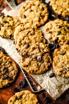 cookies and raisins sitting on top of parchment paper next to a cooling rack