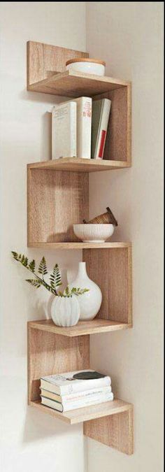 three wooden shelves with books and vases on them