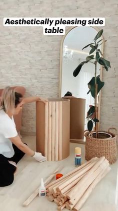 a woman sitting on the floor next to some wooden sticks and glues in front of a mirror