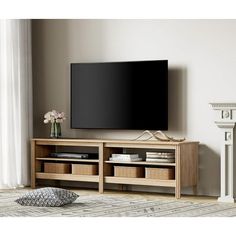 a flat screen tv sitting on top of a wooden entertainment center next to a fireplace