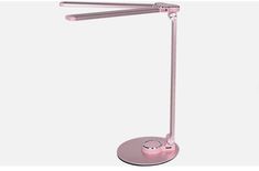 the pink desk lamp is on top of a white surface and has two dim lights