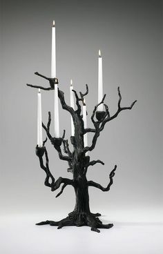 a black tree with four candles in it