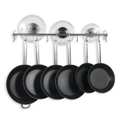 pots and pans are hanging on the wall in front of each other with glass lids