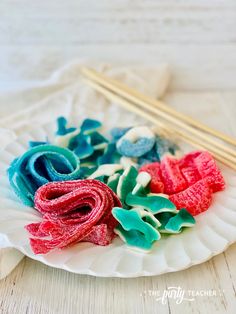 some food on a plate with chopsticks next to it