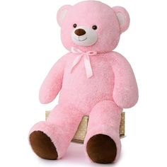 a large pink teddy bear sitting on top of a wooden box with a ribbon around it's neck