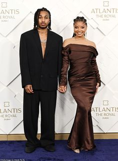 two people standing next to each other on a blue carpet