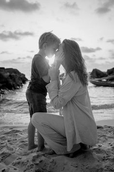 a mother kissing her son on the beach