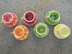 five different cups and saucers with slices of fruit in them on the ground next to each other