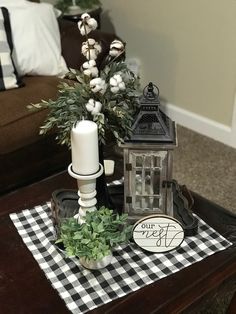 a table with a candle, potted plant and other decorations on top of it