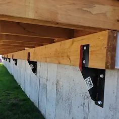 several mailboxes are attached to the side of a building with grass and trees in the background