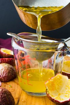 a pitcher filled with liquid next to some fruit