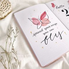 an open notebook with writing on it and a butterfly drawn on the page next to it