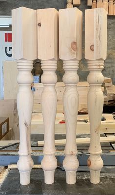 four white candlesticks sitting on top of a table