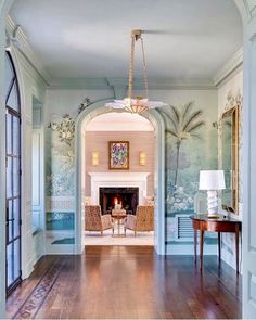 a living room filled with furniture and a fire place under a painting on the wall