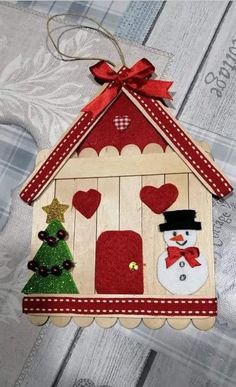 a small wooden house with a snowman and christmas tree on the door hanger