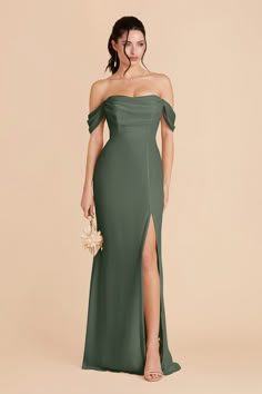 a woman in a green dress with an off the shoulder slit