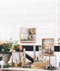 a table topped with pictures and vases filled with flowers