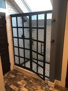 an open shower door in a bathroom with tile flooring