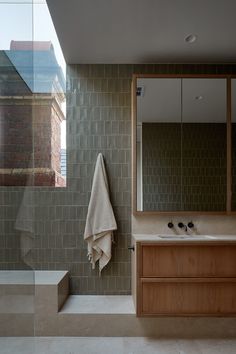 a bath room with a sink a mirror and a towel hanging on the side of it