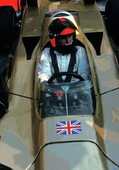 a man sitting in a race car with the british flag on it