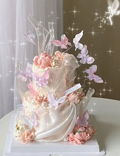 a wedding cake decorated with pink flowers and butterflies