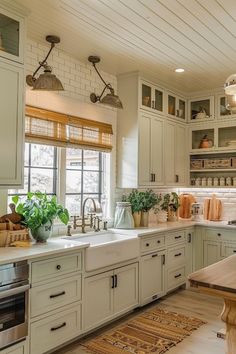 a kitchen filled with lots of white cabinets and counter top space next to a window