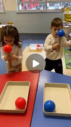 two children are playing with plastic balls in a classroom