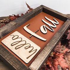 a close up of a sign with leaves on the ground