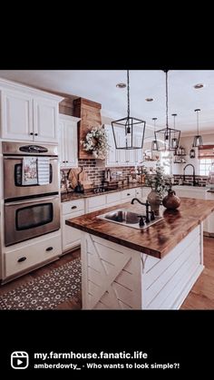 a large kitchen with white cabinets and wooden counter tops, an island in the middle