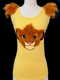 a women's yellow tank top with a lion face on the front and an orange furry tail