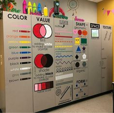 an office cubicle with many different colors and shapes on the wall, including markers