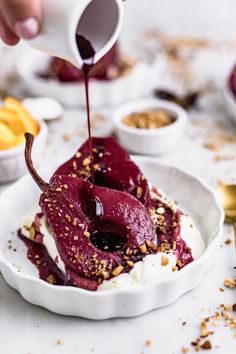 someone pouring syrup on some food in a bowl