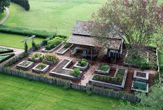 an aerial view of a vegetable garden in the middle of a grassy area with a shed