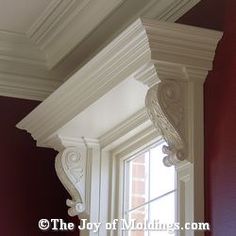 the corner of a window in a red room with white corbge and moldings