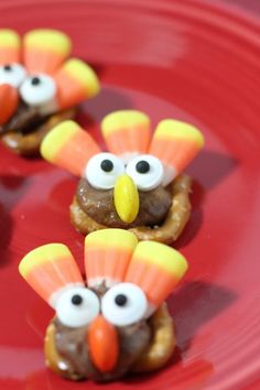 some food on a red plate with fake turkeys and candy eyes in the middle