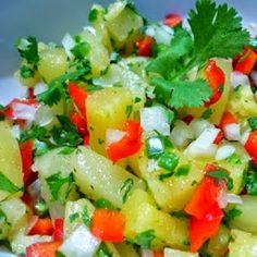 a white bowl filled with chopped vegetables and cilantro