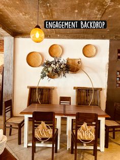 a dining room table with chairs and baskets on the wall above it that says engagement backdrop