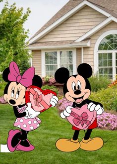 two mickey and minnie mouse cut outs standing in front of a house holding a heart