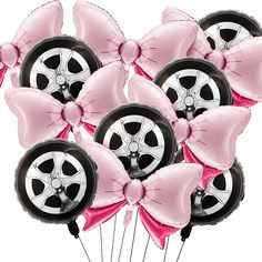 a bunch of pink and black balloons in the shape of wheels with bows on them