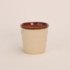 a white and brown cup sitting on top of a table