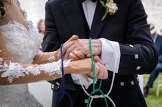 a bride and groom holding hands during their wedding ceremony at the same time as they hold each other's hands