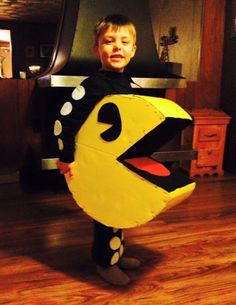 a little boy that is standing in the floor with a paper mache shaped like a bird