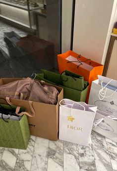 several bags are sitting on the floor in front of a store window and one is open