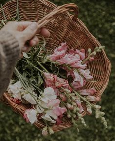 a person holding flowers in a wicker basket