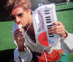 a man sitting on the ground with an old fashioned radio in his hand and sunglasses